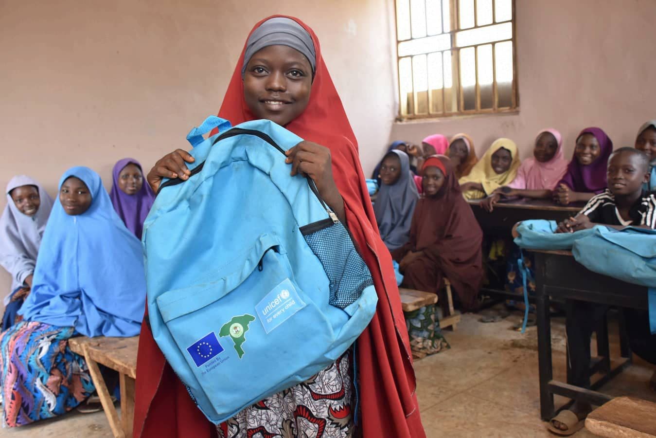 ABEP learner showing her EU and UNICEF school bag in a learning centre classroom