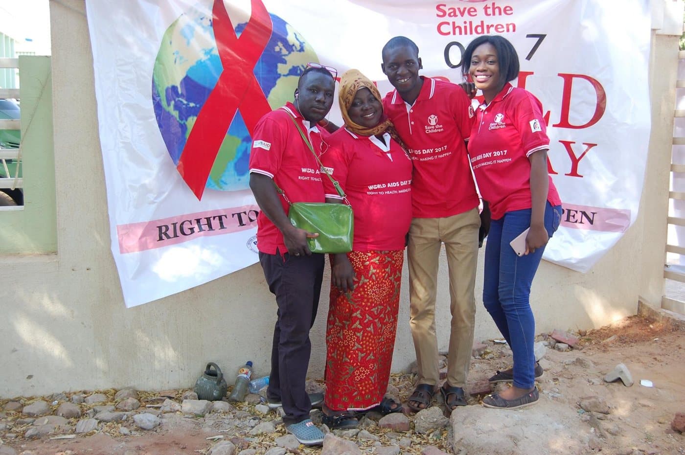 LHI team in World AIDS Day 2017 T-shirts in front of a Save the Children banner