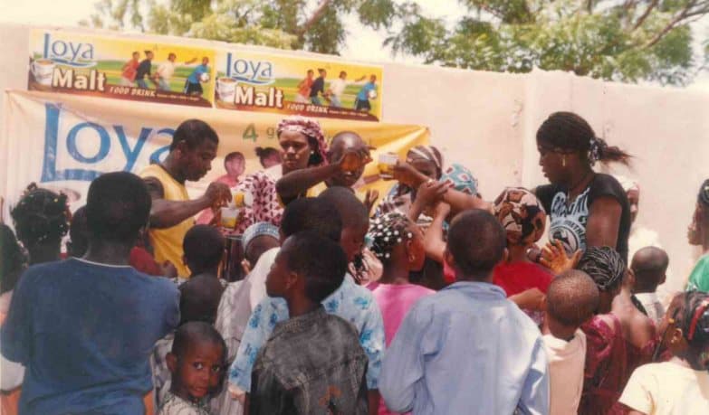 Volunteers sharing drinks with children at an early LHI children's event