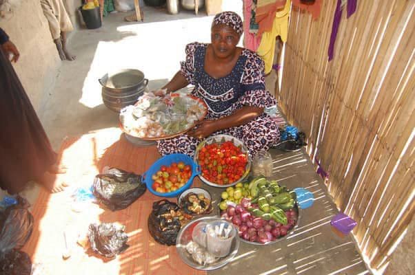 Woman arranging fresh vegetables for sale in her compound