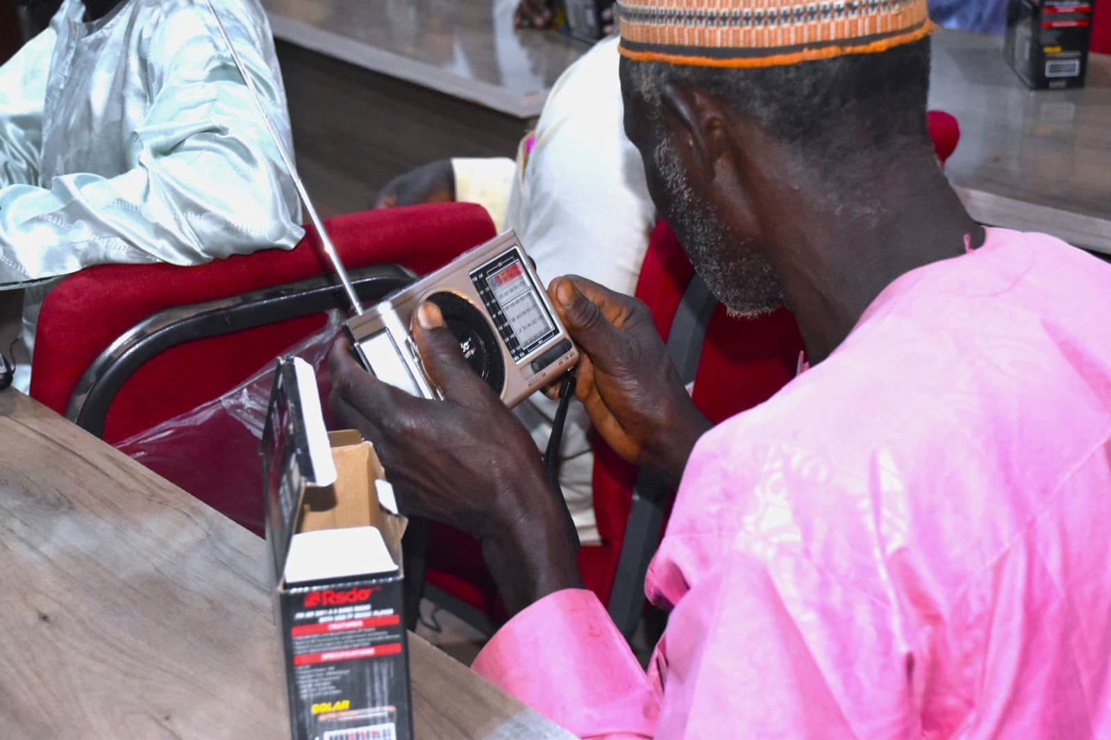 Farmer receiving a solar-powered radio for agricultural information